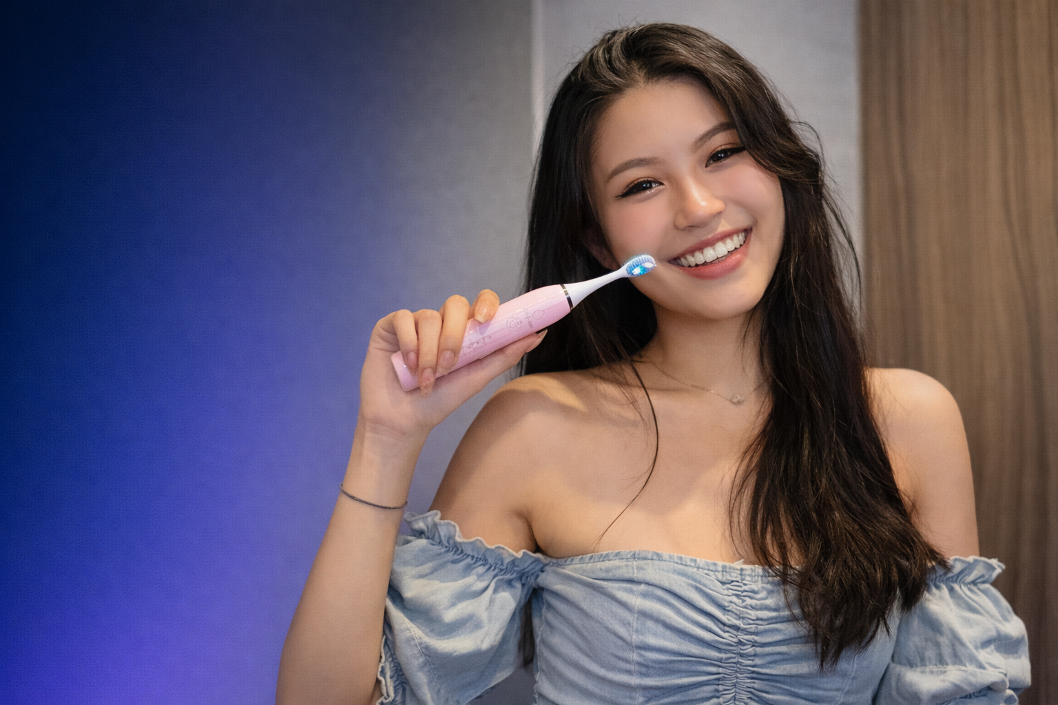 Woman holding an electric toothbrush with a blue background